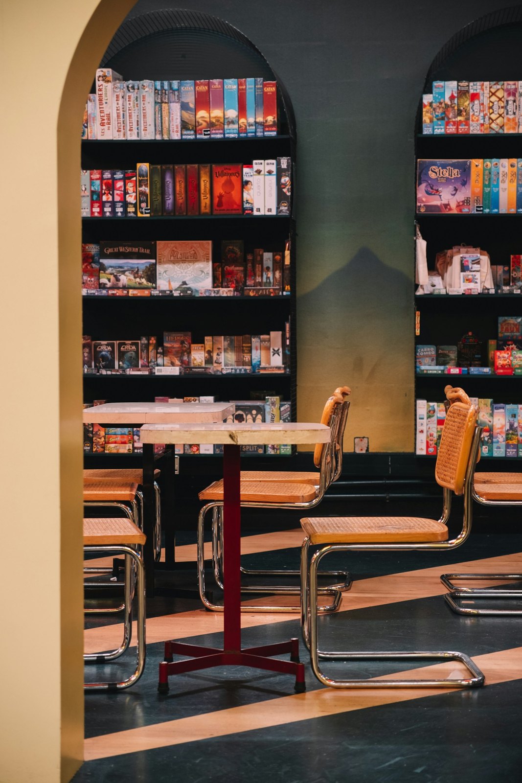Tables and shelves of boxed games in a board game cafe