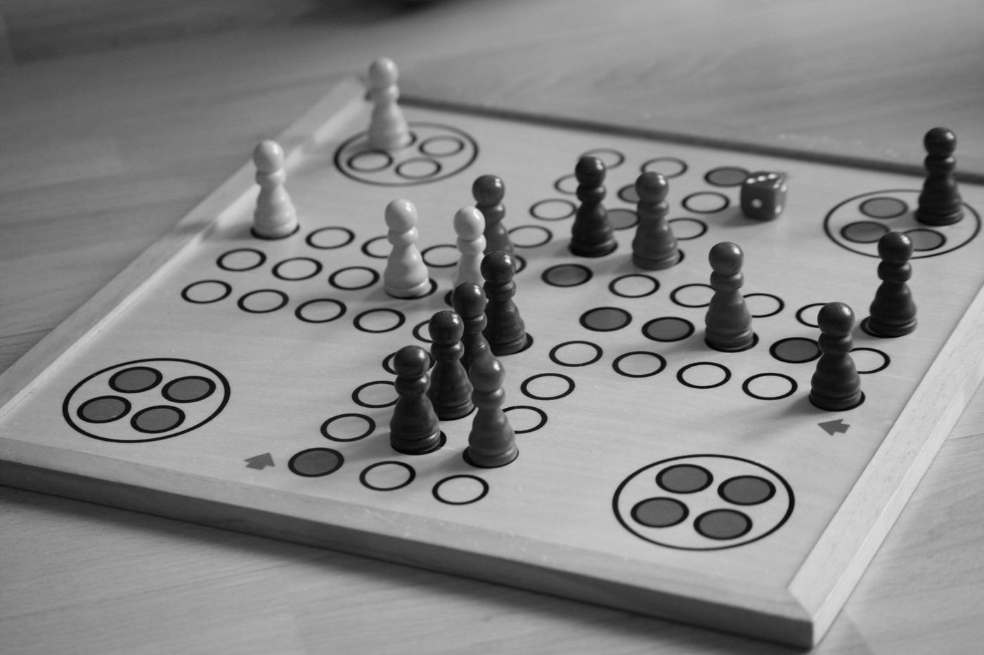 A board with simple circular spaces and wooden pawns