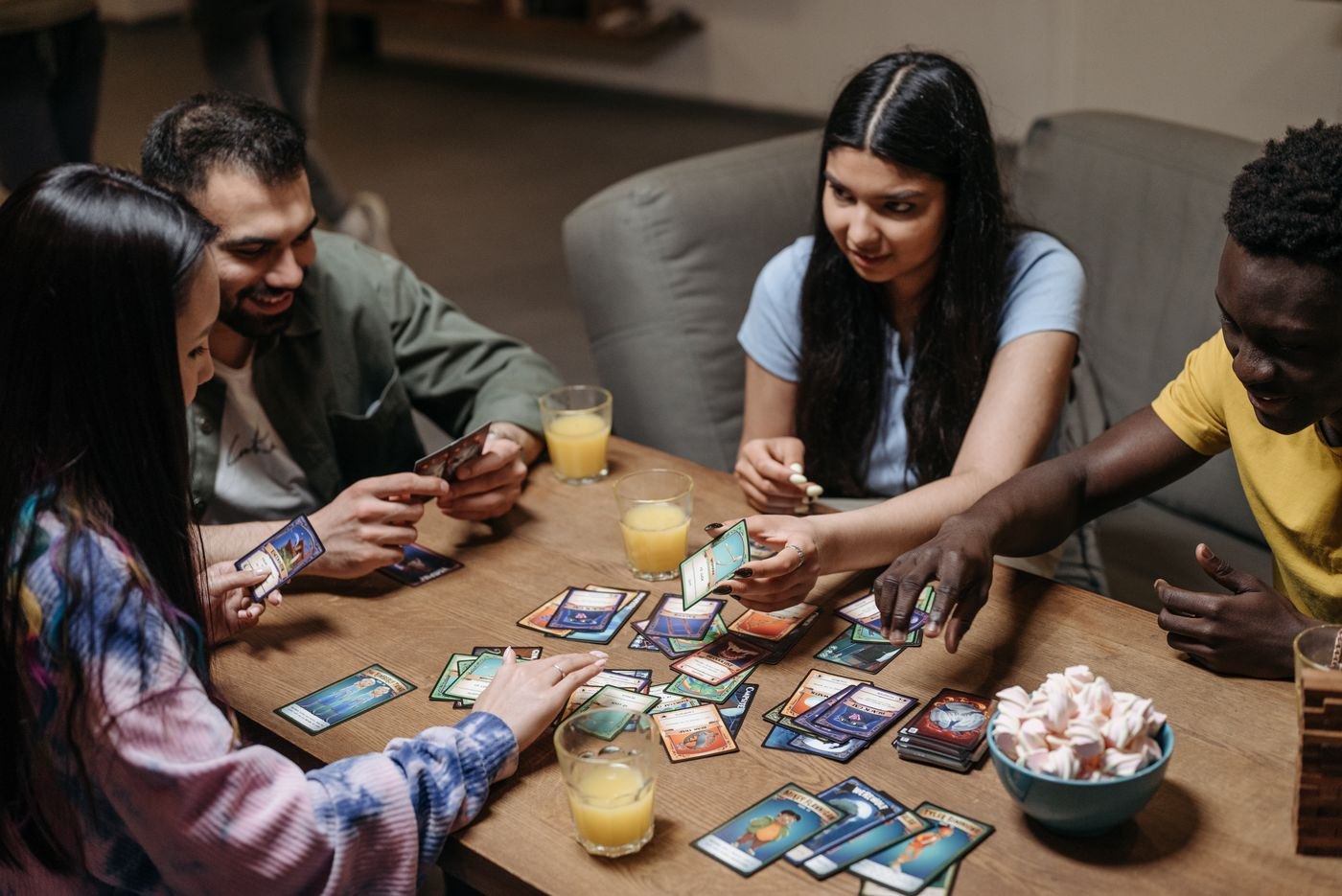 Friends discussing illustrated cards spread on a table