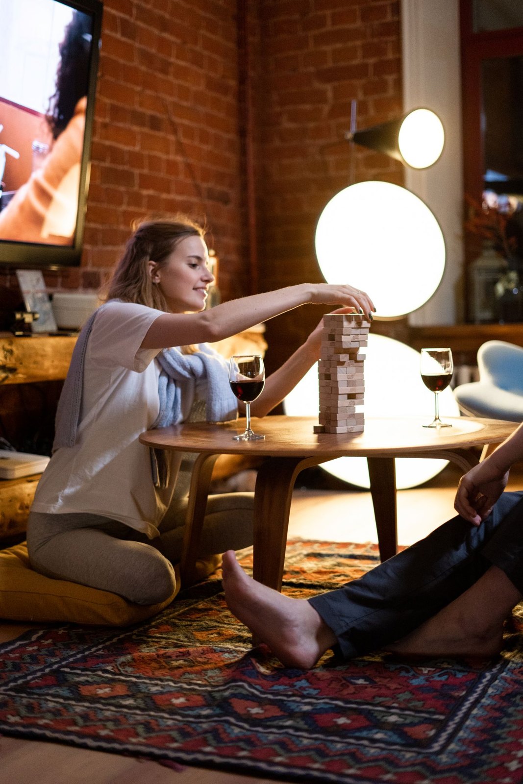 Two people playing a wooden stacking game together at home