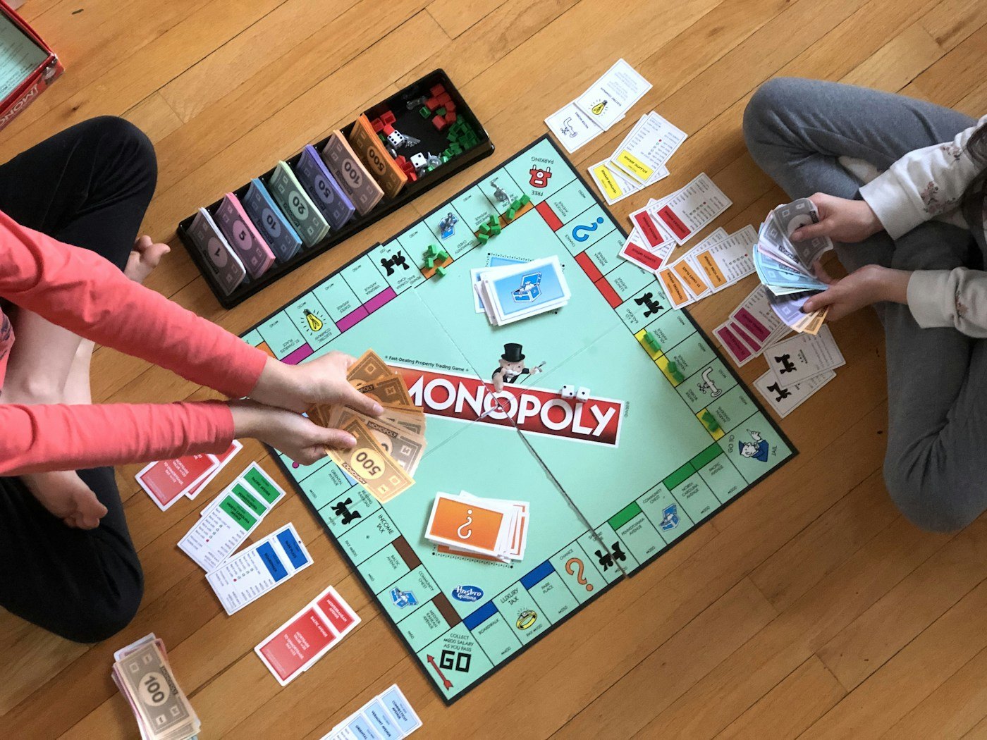 Two people seated close to a game board on the floor