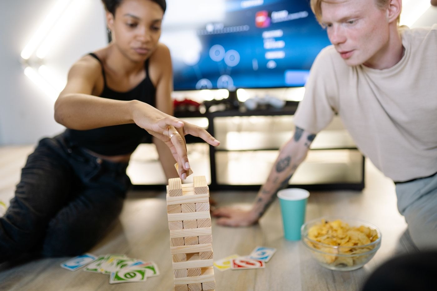 A player carefully pulling a block from a wooden tower