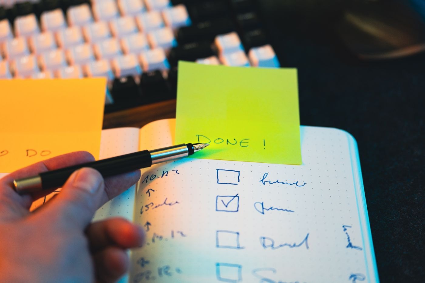 A hand checking items in a notebook checklist
