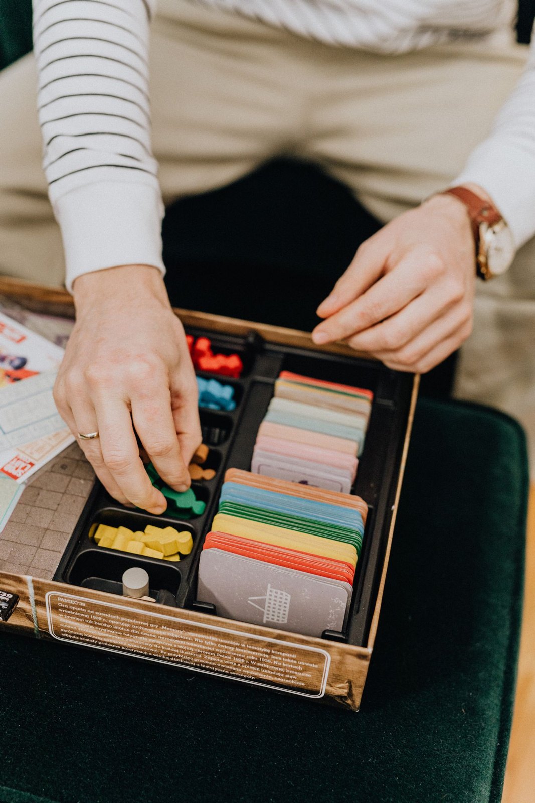 A divided board game insert holding cards and coloured pieces